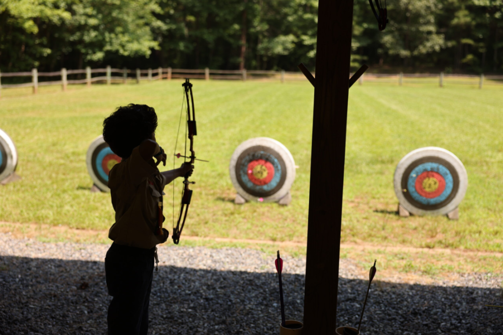A scout tries archery at Camp Durant.